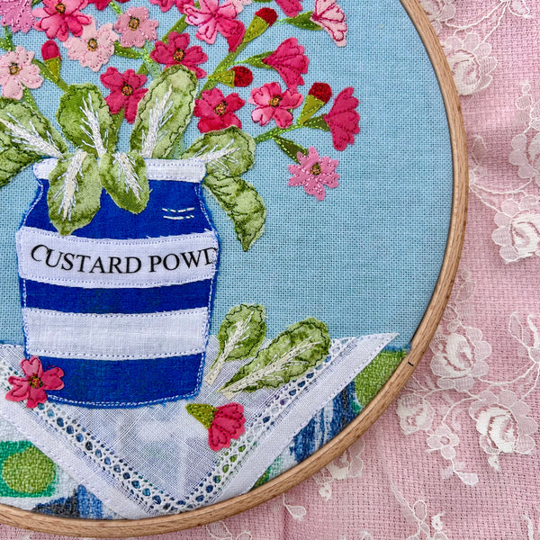 Hooped Picture - Embroidered Birds-eye primrose in a custard powder pot.