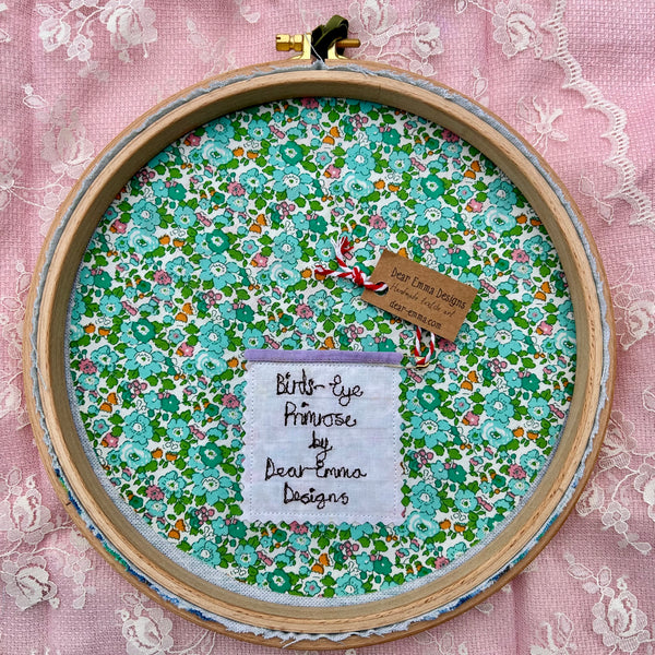Hooped Picture - Embroidered Birds-eye primrose in a custard powder pot.