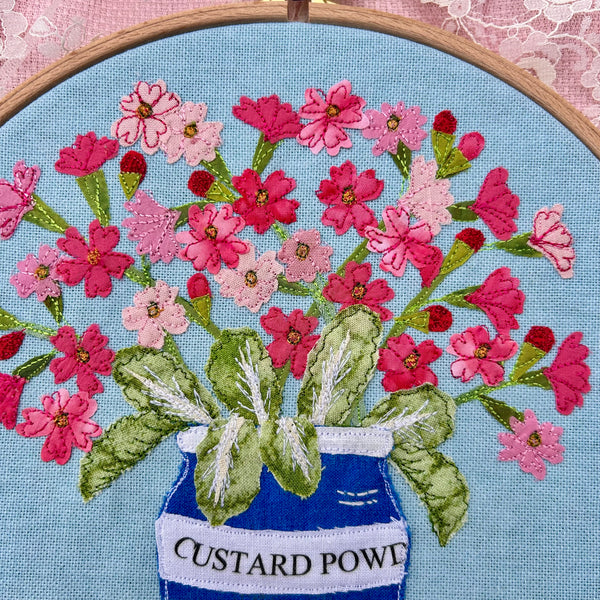 Hooped Picture - Embroidered Birds-eye primrose in a custard powder pot.